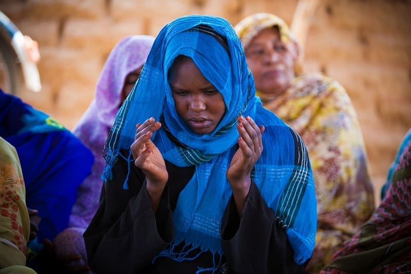 A woman at prayer in Sudan, a country in which we have worked for over 30 years.